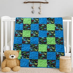 Dinosaur Dreams Baby Quilt on white crib with bear