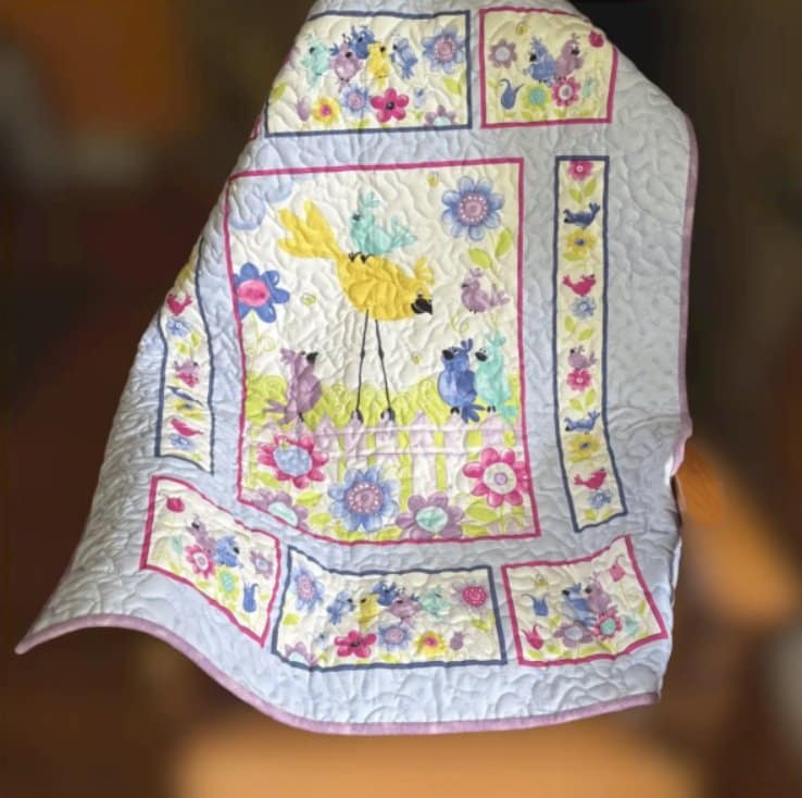 bird song in bloom baby quilt on chair